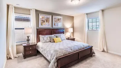 a bedroom with a bed with two night stands and two windows at ROM2112 in Los Angeles