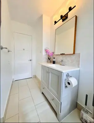 a white bathroom with a sink and a mirror at Los Angeles Blue Nest in Monterey Park