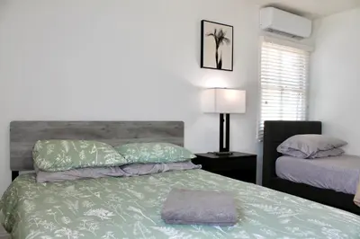 a bedroom with a bed with a green comforter at Los Angeles Blue Nest in Monterey Park