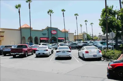 a parking lot with cars parked in front of a store at Los Angeles Gem in Monterey Park