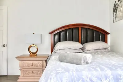 a bed with a wooden headboard and two pillows on it at Los Angeles Gem in Monterey Park