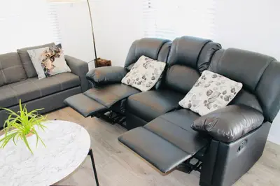 a living room with a leather couch and a table at Los Angeles Gem in Monterey Park