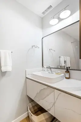 a white bathroom with a sink and a mirror at Remodeled House Near Disneyland in Fullerton