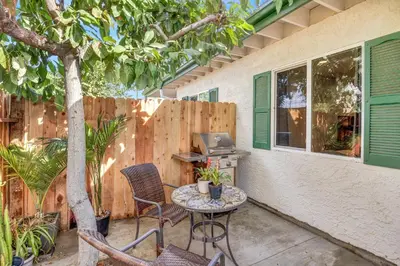 a patio with a table and chairs and a computer at Remodeled House Near Disneyland in Fullerton