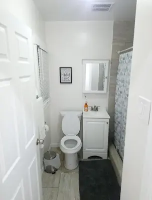 a white bathroom with a toilet and a shower at Vacation Unit is Available for Business and Family Trip in Long Beach