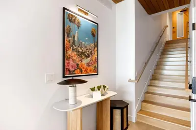 a hallway with stairs and a painting on the wall at The Santa Monica Sunset - 5k sq ft beachfront luxury in Los Angeles