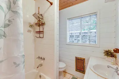 a bathroom with a tub and a toilet and a sink at Walkable Green Gables Cottage in Lake Arrowhead in Lake Arrowhead