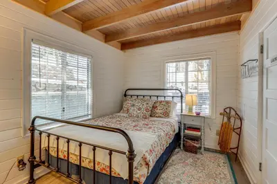 a bedroom with a bed and two windows at Walkable Green Gables Cottage in Lake Arrowhead in Lake Arrowhead