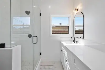 a white bathroom with two sinks and a shower at Coastal Modern 3 Bed 2 Bath, Pet Friendly in Hawthorne