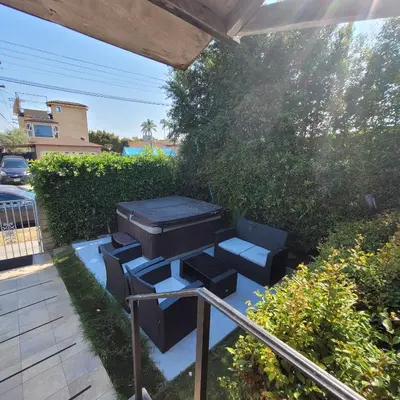 a barbecue grill and chairs on a patio at 3 bedroom 2 bath home with Jacuzzi near Beverly Hills, wi-fi, Jacuzzi, Roku, BBQ, giant games family fun in Los Angeles