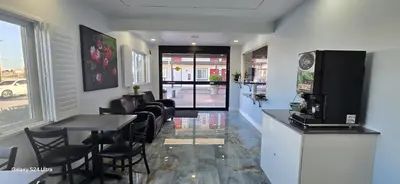 a room with a bar with a table and chairs at Hotel Avenida - Victorville, Hesperia, Apple Valley, I-15 in Victorville