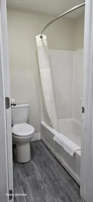 a white bathroom with a toilet and a bath tub at Hotel Avenida - Victorville, Hesperia, Apple Valley, I-15 in Victorville