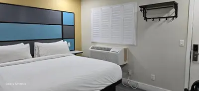 a bedroom with a white bed and a window at Hotel Avenida - Victorville, Hesperia, Apple Valley, I-15 in Victorville