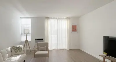 a white living room with a couch and a tv at Seaside Escape Steps from Santa Monica Beach in Los Angeles