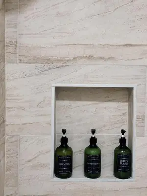 two green bottles of soap in a niche in a bathroom at Cozy Private Room A in S Central LA in Los Angeles