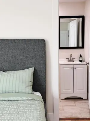 a bedroom with a bed with a mirror and a sink at Cozy Private Room A in S Central LA in Los Angeles