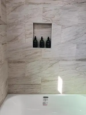 three black bottles sitting on a wall in a bathroom at Cozy private room B in S Central LA in Los Angeles