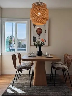 a dining room table with chairs and a vase with flowers at Cozy Private Room C in S Central LA in Los Angeles
