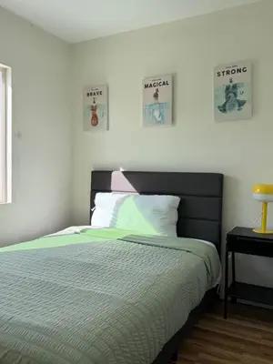 a bedroom with a bed and two pictures on the wall at Cozy Private Room C in S Central LA in Los Angeles
