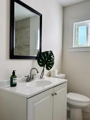 a bathroom with a sink and a toilet and a mirror at Cozy Private Room C in S Central LA in Los Angeles