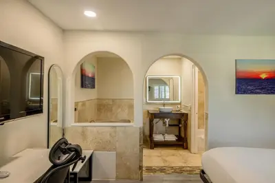 a bathroom with a bed and a tub and a sink at Hotel Avenida Victorville I 15 in Victorville