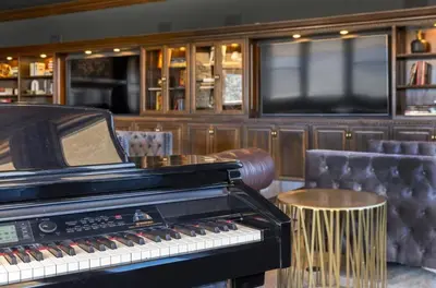 a piano and a stool in a room with a television at A California Country Experience - Tehachapi in Tehachapi