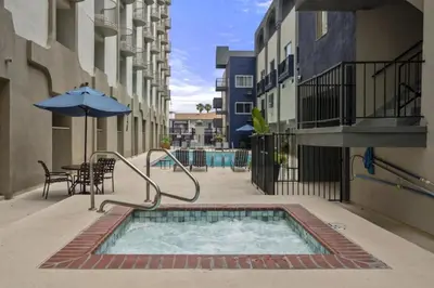 a swimming pool in a courtyard with an umbrella at Walk to Santa Monica Beach & Pier I Free Parking! in Los Angeles