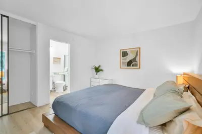 a white bedroom with a bed and a bathroom at High Ceilings 3BR with Loft-2 Baths Pool & Jacuzzi in Tarzana