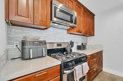 a kitchen with a stove and a microwave at High Ceilings 3BR with Loft-2 Baths Pool & Jacuzzi in Tarzana
