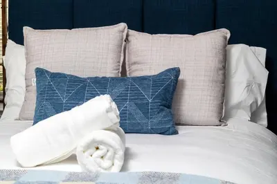 a white bed with pillows and a towel on it at Off Grid Mountaintop Paradise Pool Spa and Games in San Bernardino
