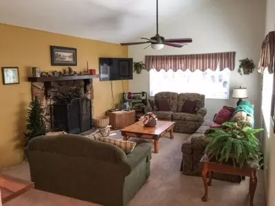 a living room with two couches and a fireplace at Spacious cozy chalet huge deck over seasonal creek in Big Bear City Airport
