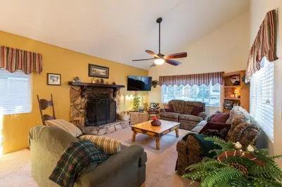 a living room with couches and a fireplace at Spacious cozy chalet huge deck over seasonal creek in Big Bear City Airport