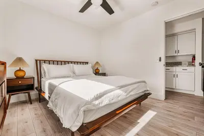 a white bedroom with a large bed and a kitchen at 5BR Fun Haven Pool Mini Golf Movie Game room in Riverside