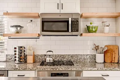 a kitchen with a stove and a microwave at 5BR Fun Haven Pool Mini Golf Movie Game room in Riverside