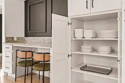 a kitchen with white cabinets and plates on shelves at 5BR Fun Haven Pool Mini Golf Movie Game room in Riverside