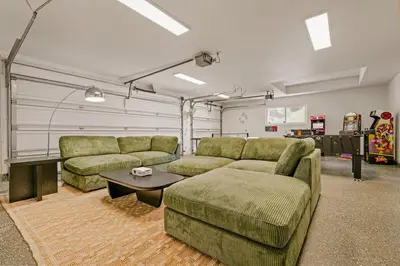 a living room with two couches and a table at 5BR Fun Haven Pool Mini Golf Movie Game room in Riverside