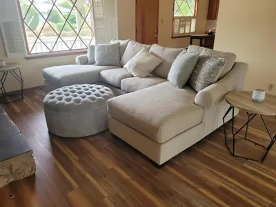 a living room with a couch and a ottoman at Extremely Chill 3 Bedroom Home in Long Beach