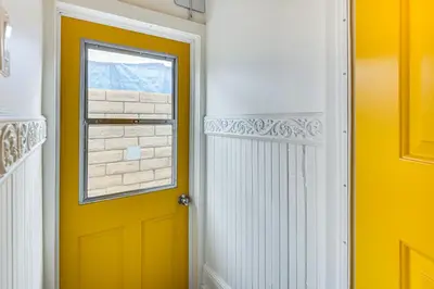 a yellow door in a hallway with a window at Home 1 Mi to DTLA Room to Work and Relax! in Los Angeles