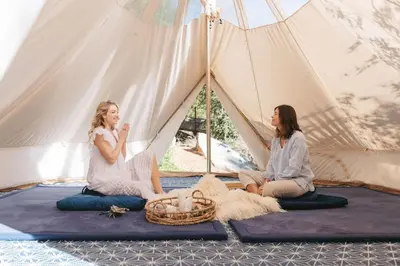 two women sitting inside of a tent at Topanga Canyon Oasis by Colby & Conrad in Topanga