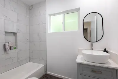 a white bathroom with a sink and a mirror at Stylish Long Beach Retreat Walk to Beach Bars in Long Beach