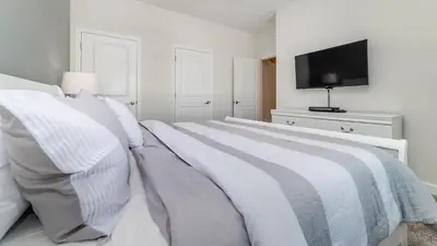 a white bedroom with a bed and a flat screen tv at LBL4837 in Los Angeles