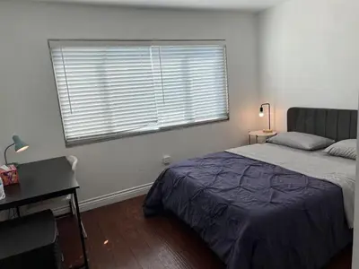 a bedroom with a bed and a desk and a window at \u5b89\u9759\u6574\u6d01\u4fbf\u6377\u7684\u72ec\u7acb\u623f\u5b50 in Baldwin Park