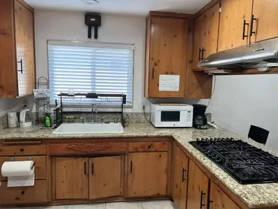 a kitchen with wooden cabinets and a sink and a microwave at \u5b89\u9759\u6574\u6d01\u4fbf\u6377\u7684\u72ec\u7acb\u623f\u5b50 in Baldwin Park
