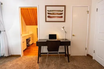 a desk with a laptop on it in a room at Stunning secluded Creekside A-Frame gameroom in Lake Arrowhead