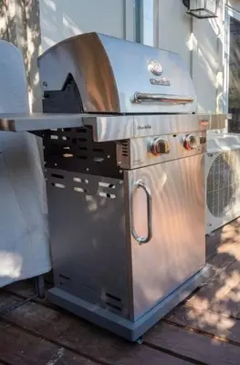 a grill sitting on a patio with a table at Stunning secluded Creekside A-Frame gameroom in Lake Arrowhead