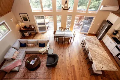 a living room with a couch and a table at Stunning secluded Creekside A-Frame gameroom in Lake Arrowhead