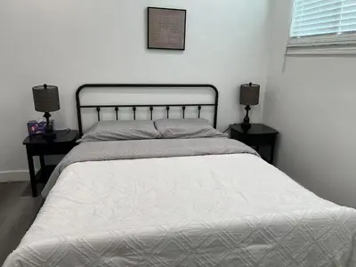 a bedroom with a white bed with two night stands at \u4fbf\u6377\u5b9c\u5c45\u7684\u72ec\u7acb\u623f\u5b50 in Baldwin Park