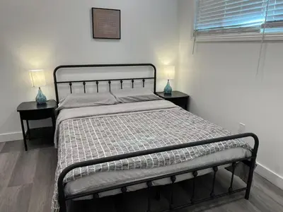 a bed in a bedroom with two nightstands and two lamps at \u4fbf\u6377\u5b9c\u5c45\u7684\u72ec\u7acb\u623f\u5b50 in Baldwin Park