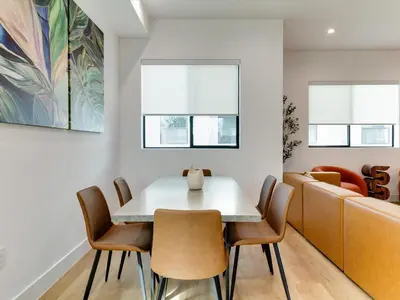 a dining room with a table and chairs and a couch at Modern Luxe Retreat Four-Bedroom in Los Angeles