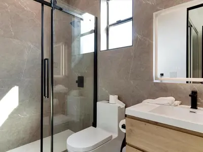 a bathroom with a shower and a toilet and a sink at Modern Luxe Retreat Four-Bedroom in Los Angeles
